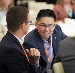 Two men talking to each other at a conference.