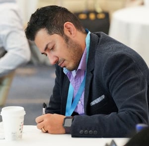 A man taking notes at a conference.